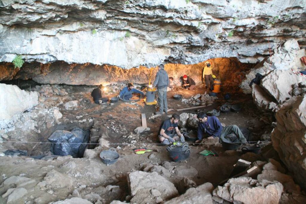 The team of researchers and archaeological finds in the site of Coro Trasito. (UAB)