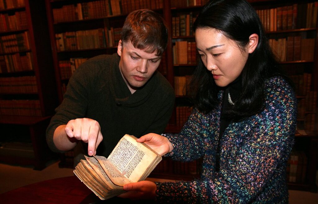 This copy of the Norwegian Code of the Realm is owned by the Gunnerus Library. Research Librarian Per-Olav Broback Rasch and Aming Shi showing the book. Photo: Idun Haugan, NTNU