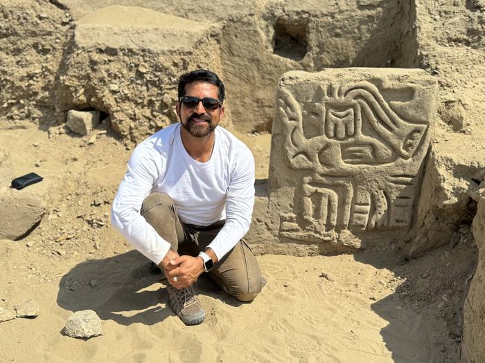 Field Museum scientist Luis Muro Ynoñán with the carving of a mythological bird creature in La Otra Banda, Cerro Las Animas. Credits: Photo by the Ucupe Cultural Landscape Archaeological Project