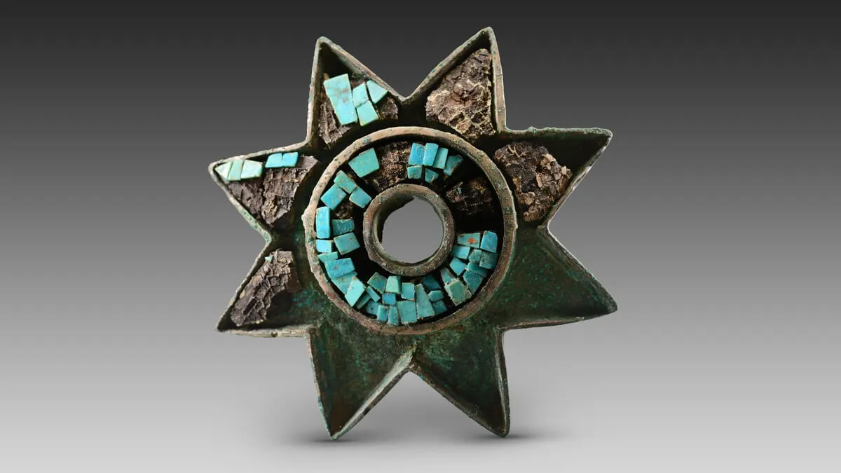 Almeno sette tombe d'élite sono state trovate nel sito di Zhaigou da quando gli scavi sono iniziati nel giugno 2022. Questa stella di bronzo intarsiata di turchese è tra le centinaia di manufatti trovati. (Crediti per la foto: Amministrazione nazionale del patrimonio culturale)