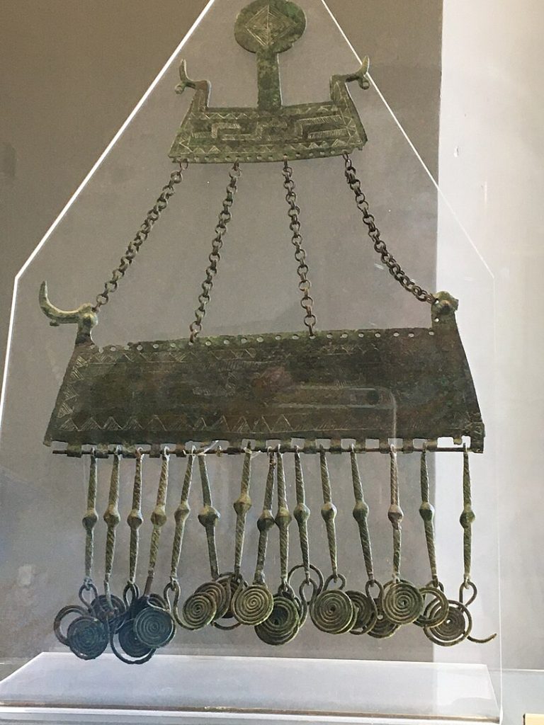 Pendaglio–pettorale con barca solare proveniente da Canavaccio di Urbino. Datazione: VIII sec. a.C. Museo Archeologico Nazionale delle Marche di Ancona