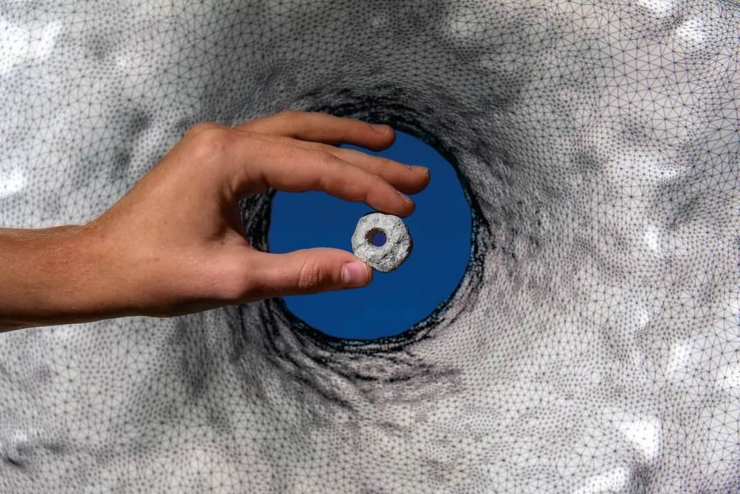 A perforated stone from NEG II in front of its 3D model. Photographer Daniel Rolider for the Smithsonian Magazine