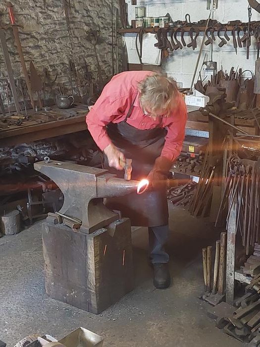 Forging a ring-handle for the replica cauldron. Photo Credits: University of Leicester