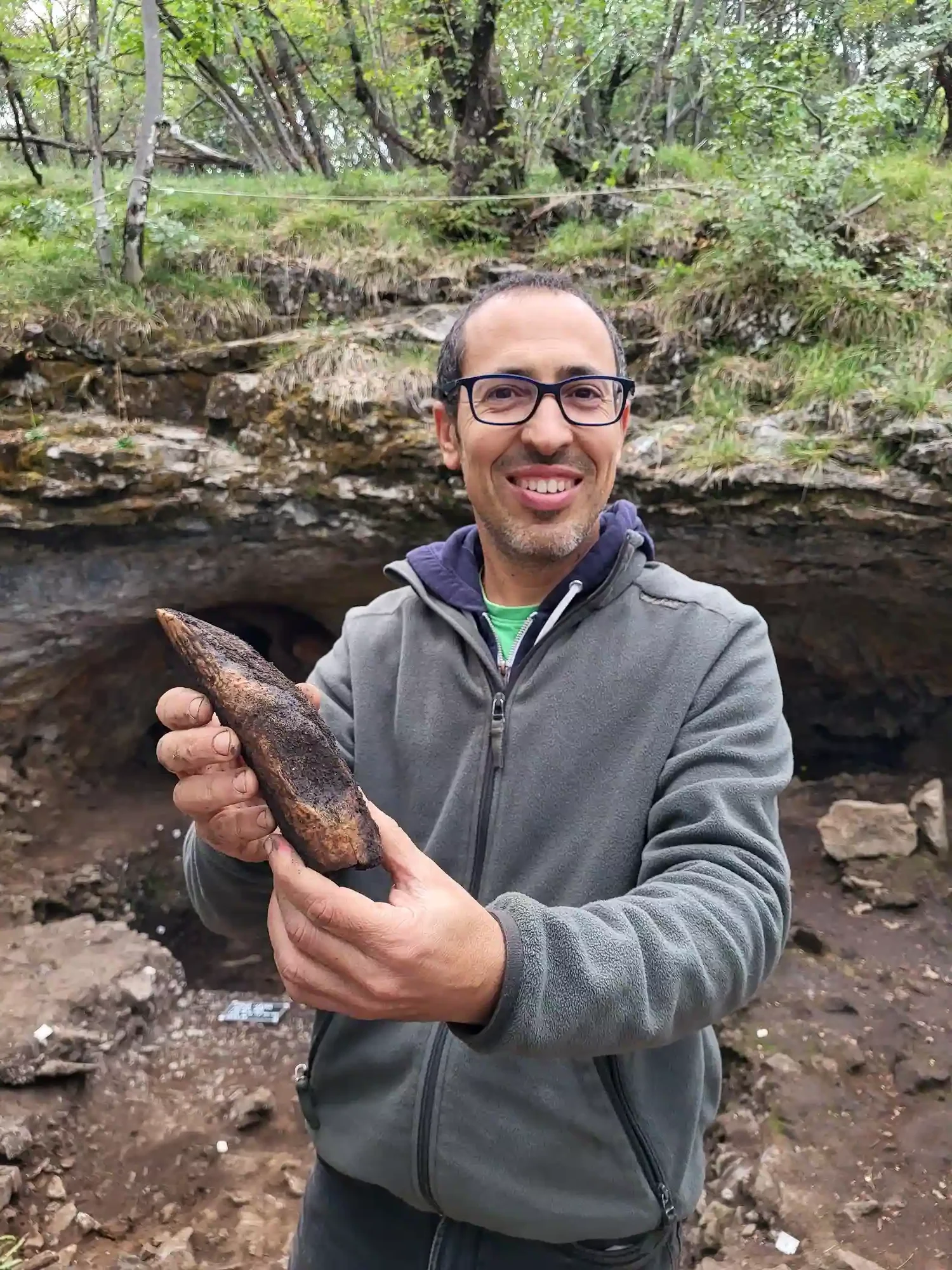 Il direttore di scavo Federico Bernardini con l'ascia appena estratta dal deposito archeologico. Foto: Gigliola Antonazzi